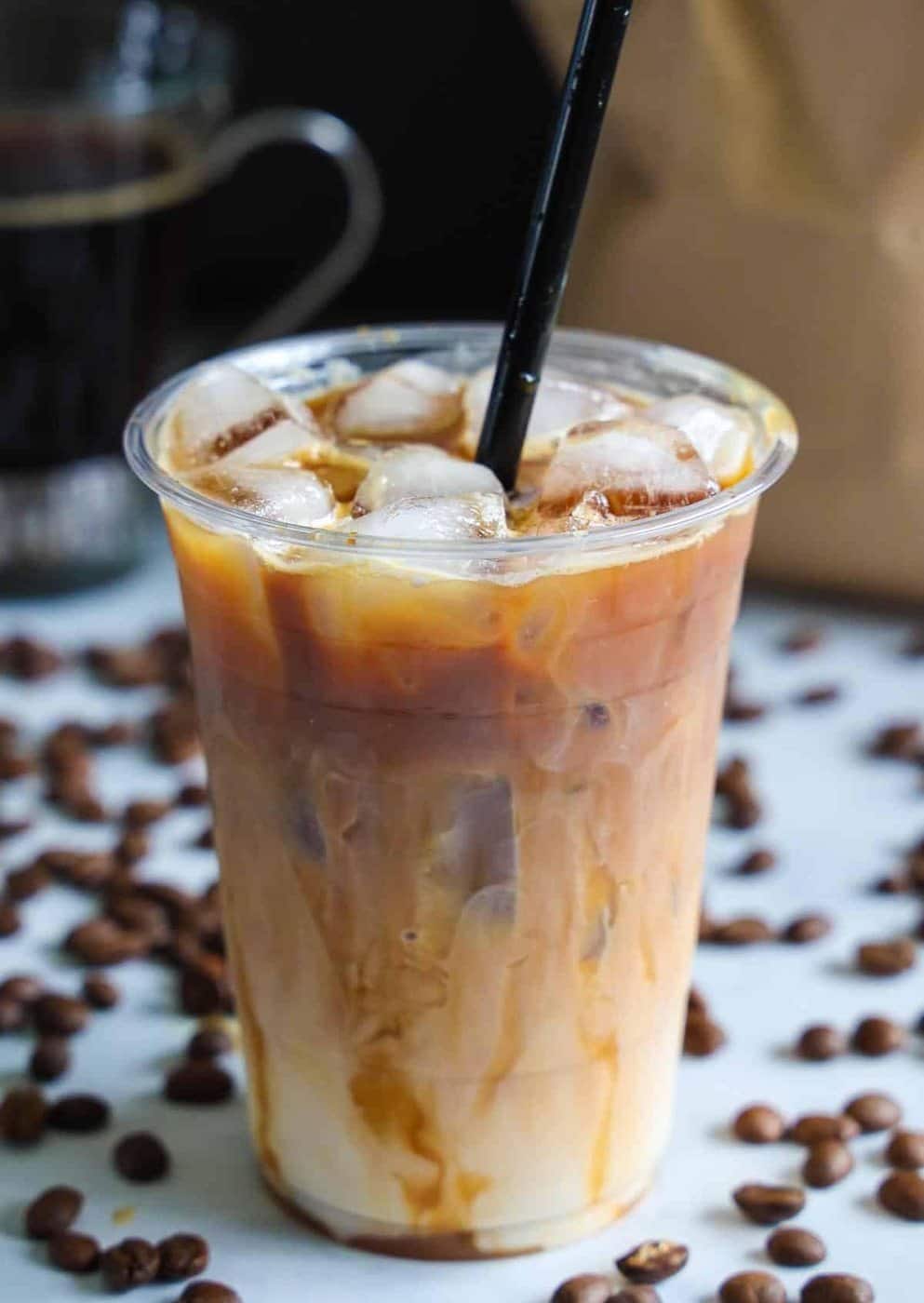 Café helado de Bloom rodeado de granos de café